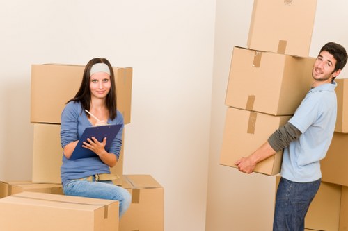 Trained movers handling furniture carefully with proper lifting technique